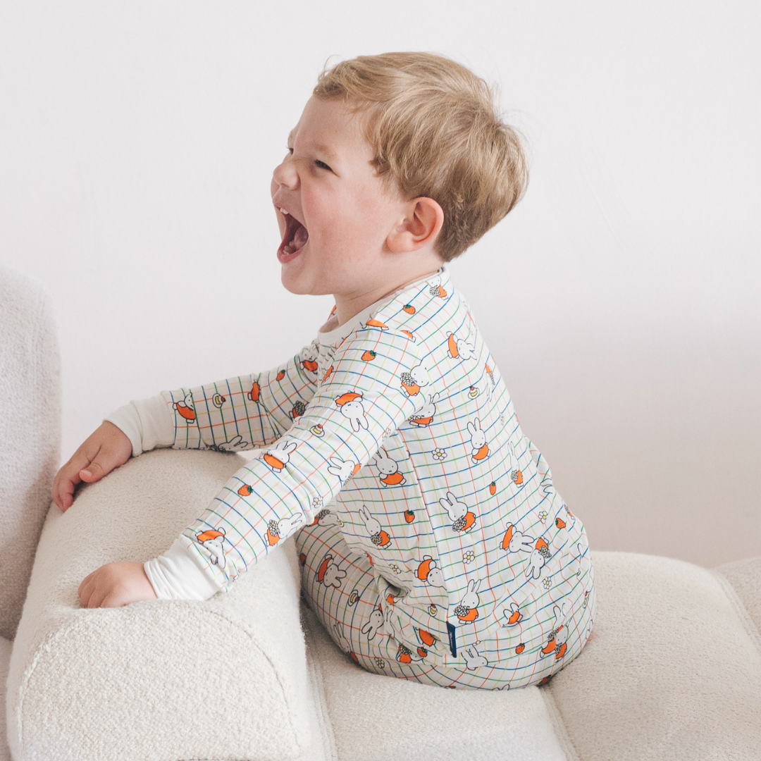 Kind, das das Bambus-Pyjama-Set „Children's Miffy Checkered Bloom“ trägt