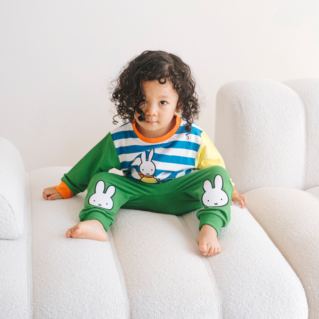 Dítě v bambusové soupravě Miffy z řady „On the Move“ s mikinou s motivem jízdního kola a zelenými teplákovými kalhotami