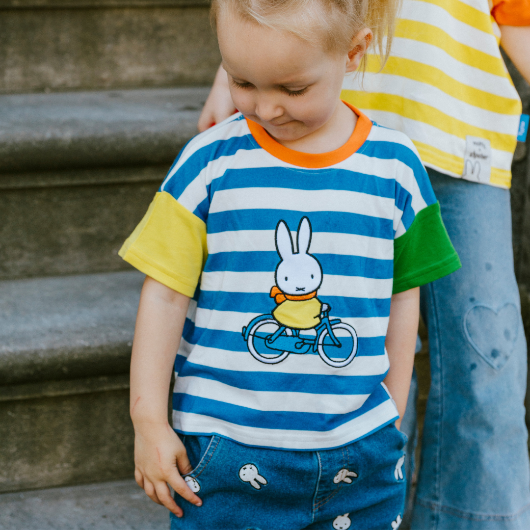 Kind dat het gestreepte kinder-T-shirt met ringer-rand nijntje van Move draagt