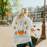 Vrouw die het nijntje witte borstvoeding-T-shirt draagt met een geborduurde tulp en borstvoedingsritsen