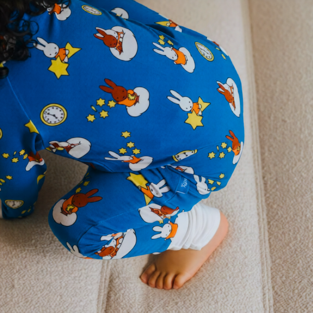 Bambino con indosso il ZIPSTER x Miffy Starry Sleep in bambù Pagliaccetto