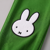 Detail designu u modelu Miffy z bambusové lounge sady „Move“ v kombinaci s mikinou s motivem jízdního kola a zelenými joggingovými kalhotami