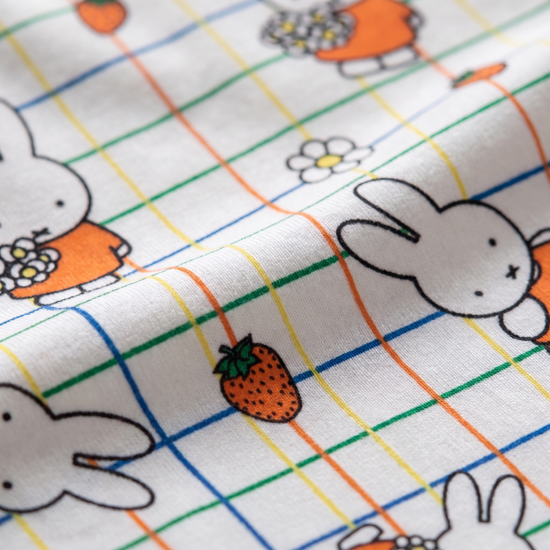 Primer plano del suave tejido de bambú del ZIPSTER x Miffy, con estampado de cuadros y flores.